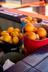 buckets with ripe lemons and oranges at the summer market