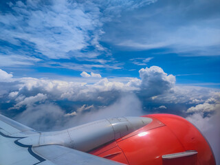 Clouds, land and sky as seen from airplane window on the wing and plane engine