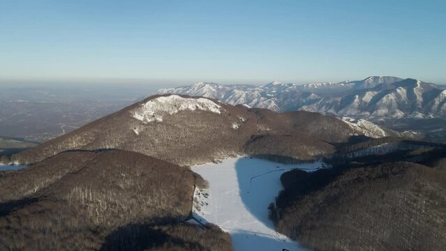 Aerial view of Verteglia Plateau with snow in wintertime at sunset on Mount Terminio, Serino, Avellino, Irpinia, Campania, Italy.