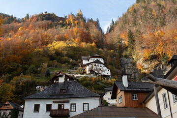 hallsttat mountain village surrounded by lakes and trees in autumn