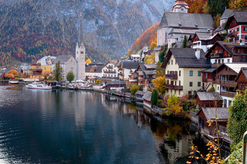 hallsttat mountain village surrounded by lakes and trees in autumn
