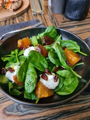 Salad with beetroot arugula greens and feta cheese walnuts in bowl.
