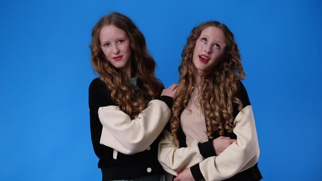 4k slow motion video of two twin girls smiling and looking at the camera.