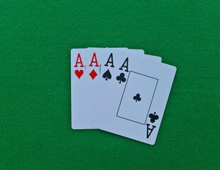 Four of kind cards of aces on green felt casino table background