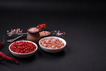 Pink himalayan salt in a wooden bowl on a dark concrete background