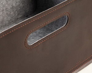 Closeup of slotted handle of brown leather storage box