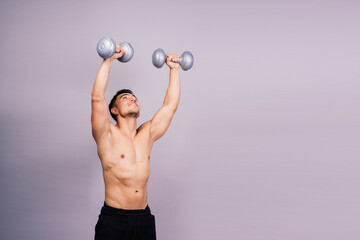 Shirtless bodybuilder showing his great body and holding dumbell.