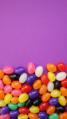 Colorful jelly beans on a purple background for Easter.