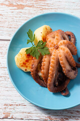 Galician style octopus on a blue plate. Typical Spanish food.