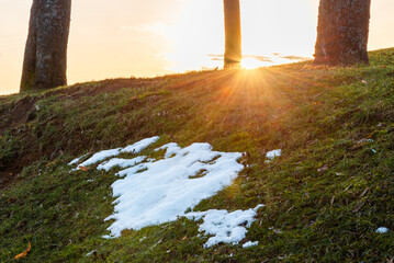 Spring landscape with melting snow and thawed patches early spring at sunset on a cloudy day in...