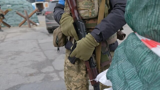 Close up of Ukrainian soldiers at the checkpoint, dressed in military uniforms holding Kalashnikov assault rifles