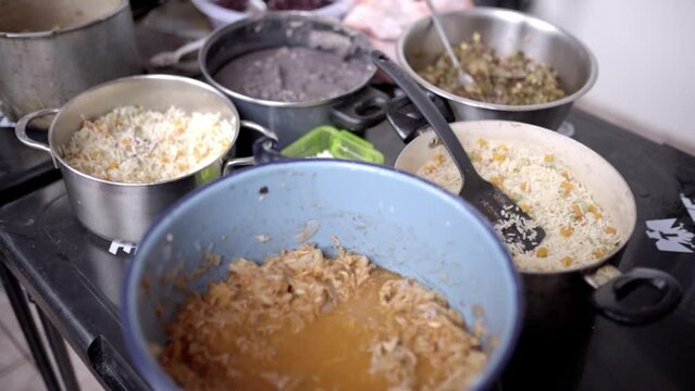 Different pots filled with tinga de pollo, stew, rice, nopal and frijoles