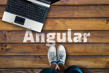 Angular web framework.  Legs in shoes standing next to laptop and word Angular
