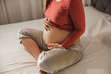 Unrecognizable Pregnant Woman On A Bed In Bedroom