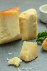 grates hard cheese on a dark background, vertical image. place for text