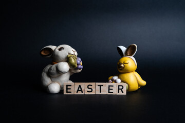 Easter concept word in wooden letters with rabbit and flea. Easter holidays concept.