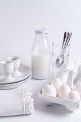 Obraz na płótnie Canvas fresh white eggs, milk bottle on white background. Front view, copy space, selective focus.