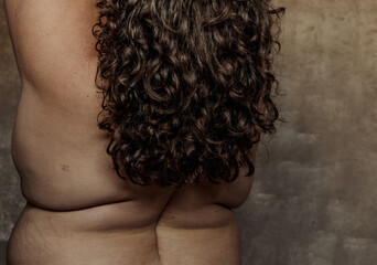 close-up portrait of a plus size woman's back showing curly hair