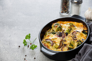 Cheese casserole with broccoli and onion in baking dish. Vegetarian recipe.