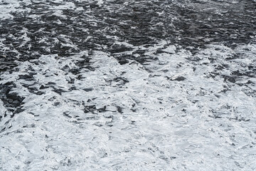 Ice crystals forming spike shapes on frozen river, closeup macro detail