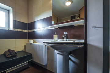 toilet and detail of a corner shower cabin with wall mount shower attachment