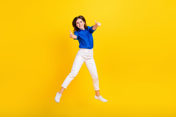 Full length photo of confident sweet lady wear blue shirt rising thumbs up empty space isolated yellow color background