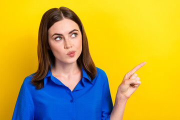 Photo of cute minded lady wear trendy blue clothes arm demonstrate empty space look interesting offer isolated on yellow color background