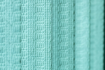 Defocused macro abstract texture background of a fabric vertical blinds surface in a turquoise green color

