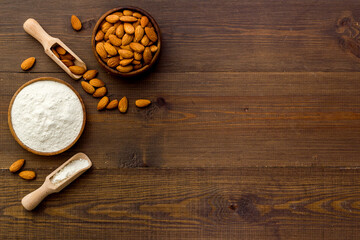Gluten free almond flour with almond nuts in bowl, top view