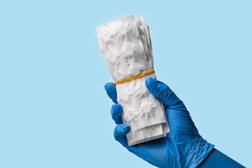 Paper blisters with pills in hand. Background, selective focus. Isolated on blue medical backdrop