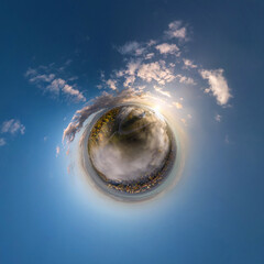 tiny planet in sky with clouds overlooking old town with fog, urban development, historic buildings...