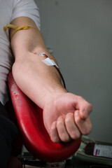 Detail with hand of a blood donor donating blood in a hospital
