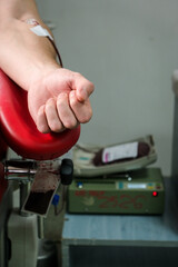 Detail with hand of a blood donor donating blood in a hospital