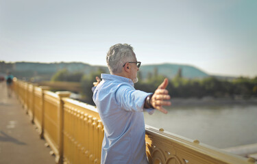 adult man breathes deeply while observing a landscape from a bridge