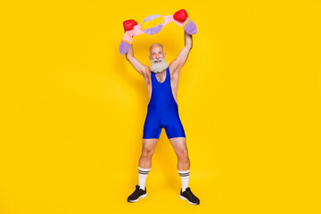 Fototapeta na wymiar Full length portrait of funky positive aged man wear boxing gloves raise arms hold soft champion belt isolated on yellow color background