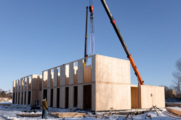 The construction process of a new and modern modular house made of composite sip panels on a sunny winter day. - obrazy, fototapety, plakaty