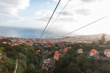 Beautiful city of Funchal with vintage houses and cable cars by the ocean, bird's eye view. The...