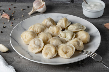 Traditional russian pelmeni, ravioli, dumplings with meat on a wooden table