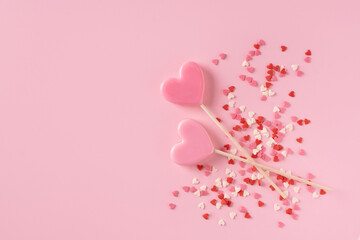 Candy pink lollipops with red gift box on pink background