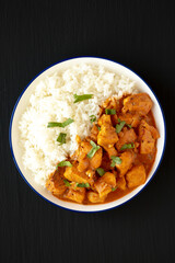 Homemade Easy Indian Butter Chicken with Rice on a Plate on a black background, top view. Flat lay, overhead, from above.