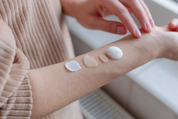 Different textured skin care products on woman's hand.