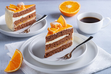 Cake, orange and coffee on a light wooden table