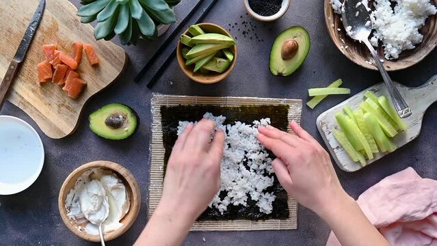 Cooking sushi process. Rice, fish fillets, cream cheese, avocado and cucumbers.