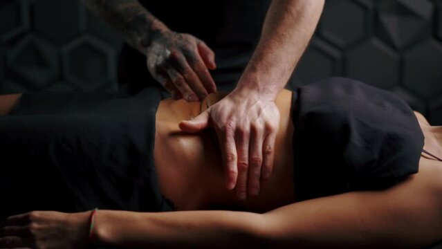Anti-cellulite abdominal massage, professional masseur uses oil for massage