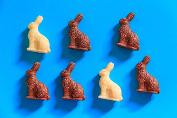 Easter chocolate bunnies on blue background. Top view