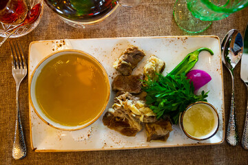 Appetizing Khashlama in Georgian recipe, soft boiled meat of young lamb served with rich broth and fresh greens