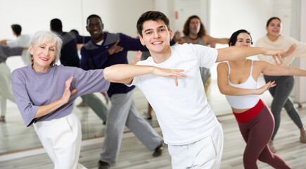 Fototapeta na wymiar Group of dancing people practicing energetic swing during a class in a dance studio