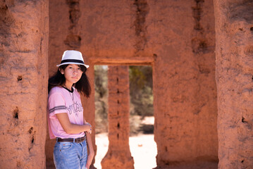 mujer adolescente con sombrero en antigua casa de adobe, Catamarca Argentina