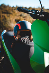 Detalhes de uma mota eletrica verde com capacete e luvas