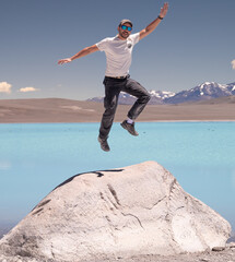 hombre parado en roca junto a laguna salada color turquesa